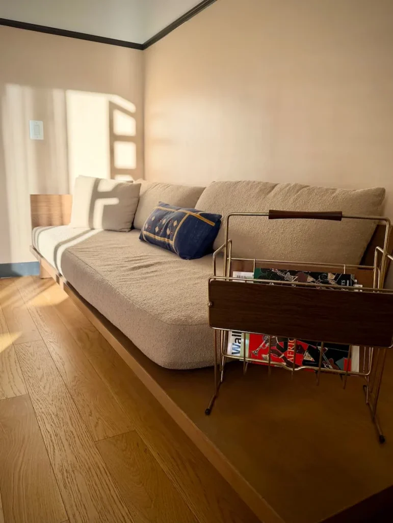 cool beige Sofa in room at Eaton DC, Washington. DC. There is a brown leather and gold metal magazine rack in front of it