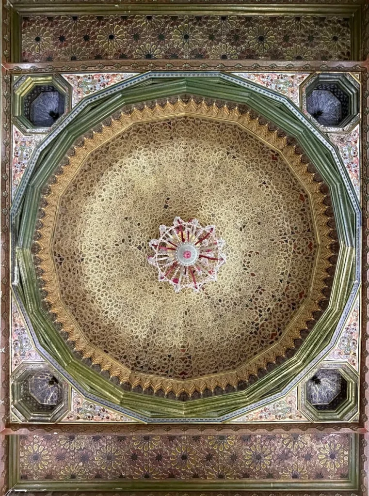 A ceiling mosaic at Bardo Museum, Tunisia with a large circle in the middle and smaller symmetrical circles on the outside encased in a large square.