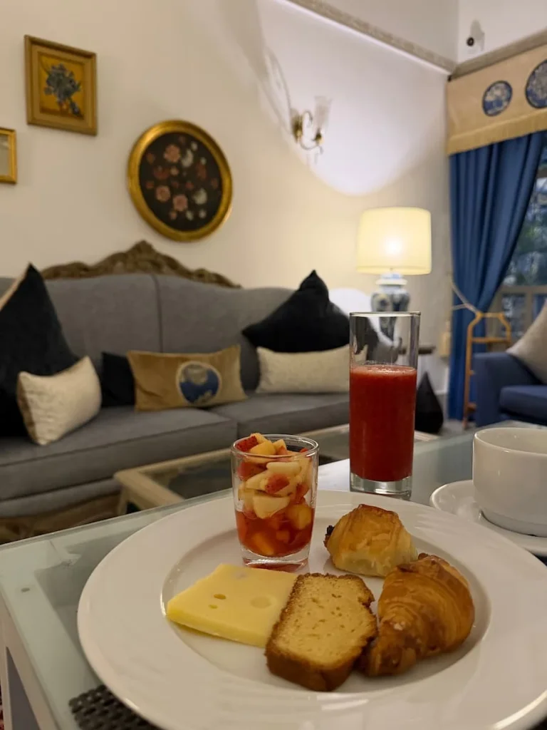 Breakfast at Dar Said in Sidi Bou Said. There is a glass of strawberry juice, pastries, cheese, bread, cake and a fresh fruit salad, Tunisia