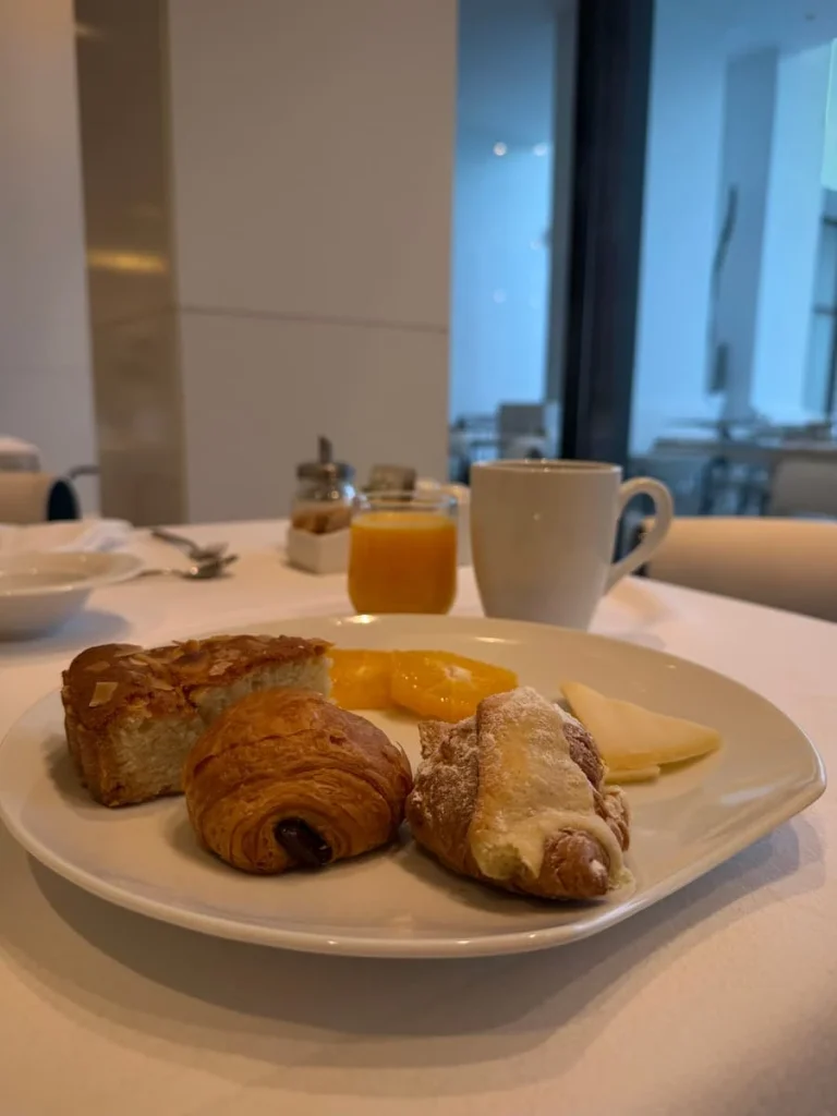 Breakfast pastries at La Badira in Hammamet. The white plate has pain au chocolat, cheese, other pastries, fruit plus a glass of orange juice and a coffee