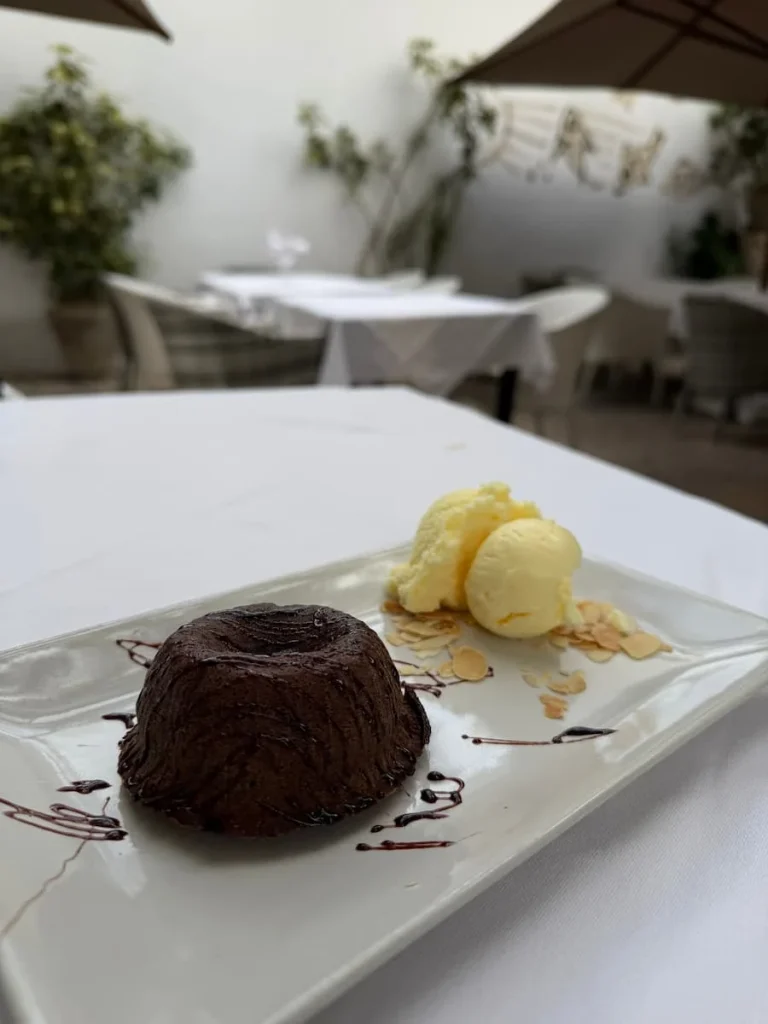Chocolate Fondant desert with homemade date ice-cream on a white oblong plate at Chex Achour, Hammamet