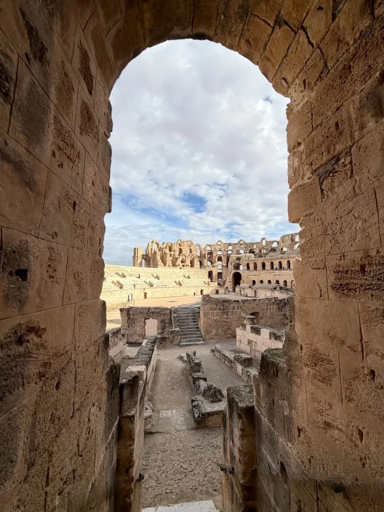 An archway window style opening in the colosseum with views into the central courtyard where games would take place,Located in El Djem, Tunisia