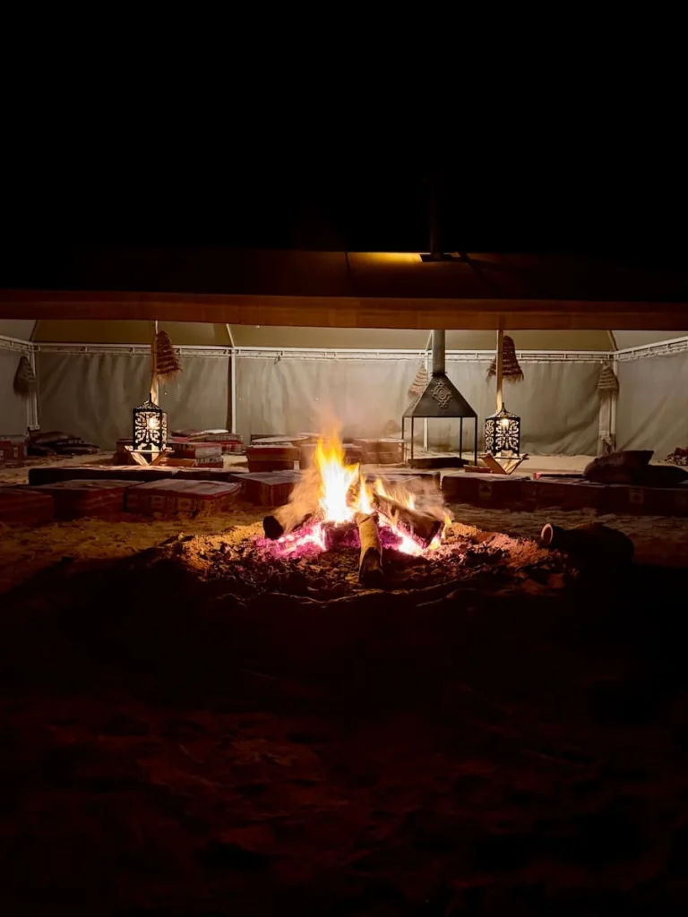 A fire lit at camp to make bread for the guests with a covered seating area at Camp Abdelmoula, Tunisia