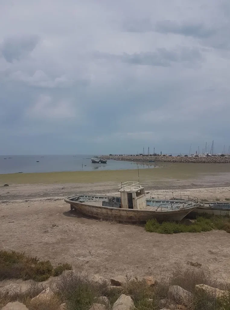 Haroun Restaurant Views looking out to the Marina with a fishing boat on the sand, Djerba