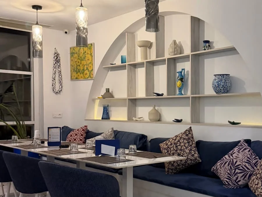Interiors at Blu Blu restaurant in Sidi Bou Said, Tunisia. There are shelves on the wall and the decor is very white washed and of a mediterranean style