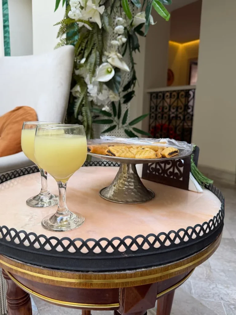 Lemon juice adn date sweets at Dar Alouini, Kairouan, Tunisia. A black edge tray has the items in it with the Dar pillars in the background