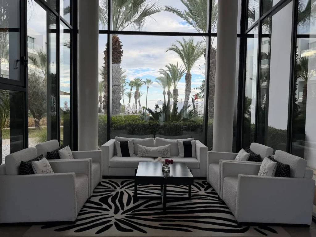 The Lobby area at La Badira in Hammamet. There are white comfy sofas with the palm trees in the background