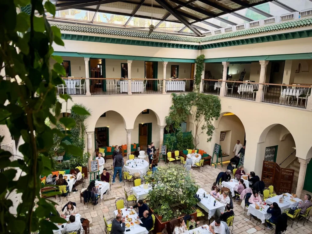 Old house restaurant, Fondouk el Attarine, Tunis Medina, Tunisia. A view of the courtyard from the top with diners and foliage framing the photo