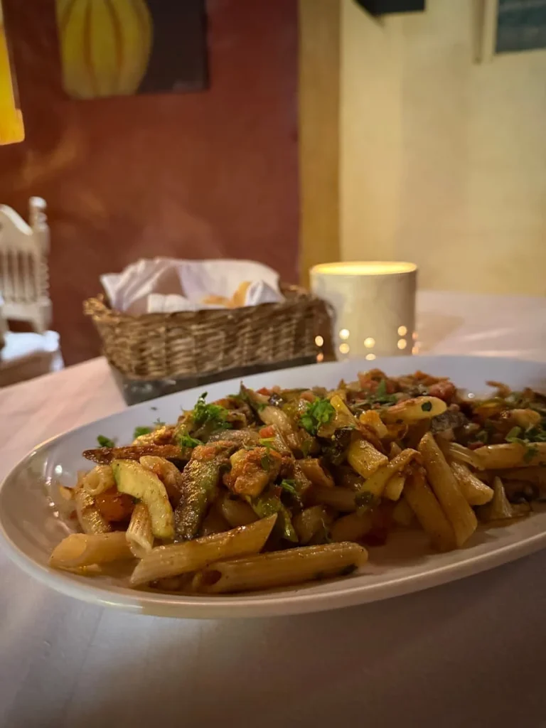 Pasta at Dar Dhiafa, Djerba, Tunisia. A vegetable pasta dish in a platter with bread in the background