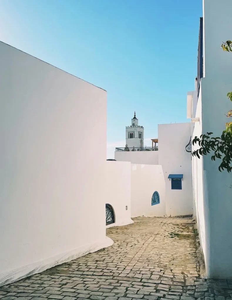 Sidi Bou Said Mosque down a white washed street, Tunisia. The Minuret emerges from a bright blue sky