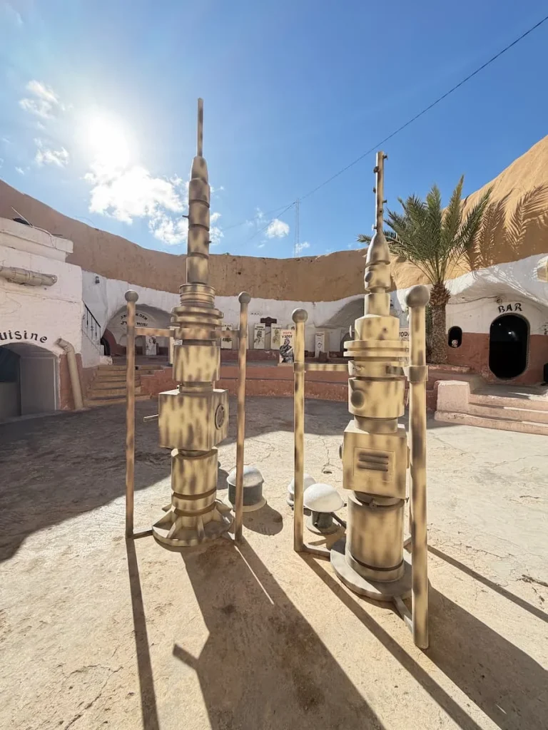 Star Wars props in Hotel Driss. The space artefacts are in the centre of the courtyard. In the background we can see the blue sky and sun shining through with palm trees, Matmata, Tunisia