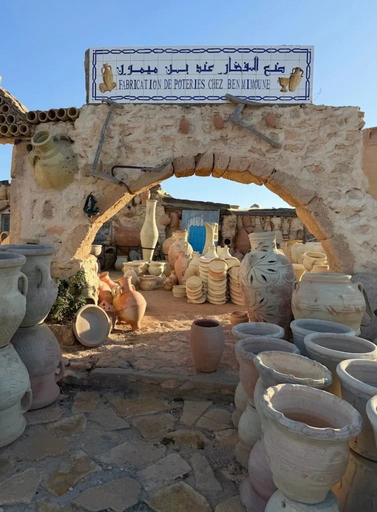 The entrance to the Ben Mimoune Potteries in Djerba, with a clay entrance and unglazed pots arranged outside 