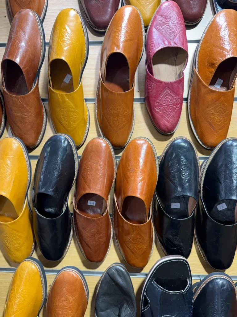 Tunisian leather slippers hanging on the wall in colours of brown, navy, orange and yellow Slippers, Sidi Bou Said, Tunisia