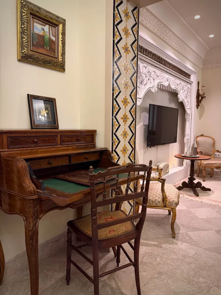 A dark wood writing desk and chair in suite 1 at Dar Alouini, Kairouan, Tunisia. There is a mosaic tiled frame around the TV