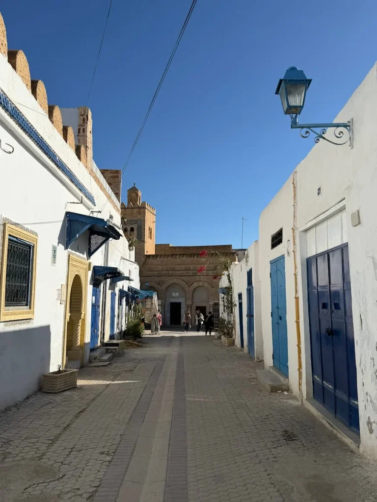 Alleyways in Kairouan Medina with blue doors at either side adn white washed buildings