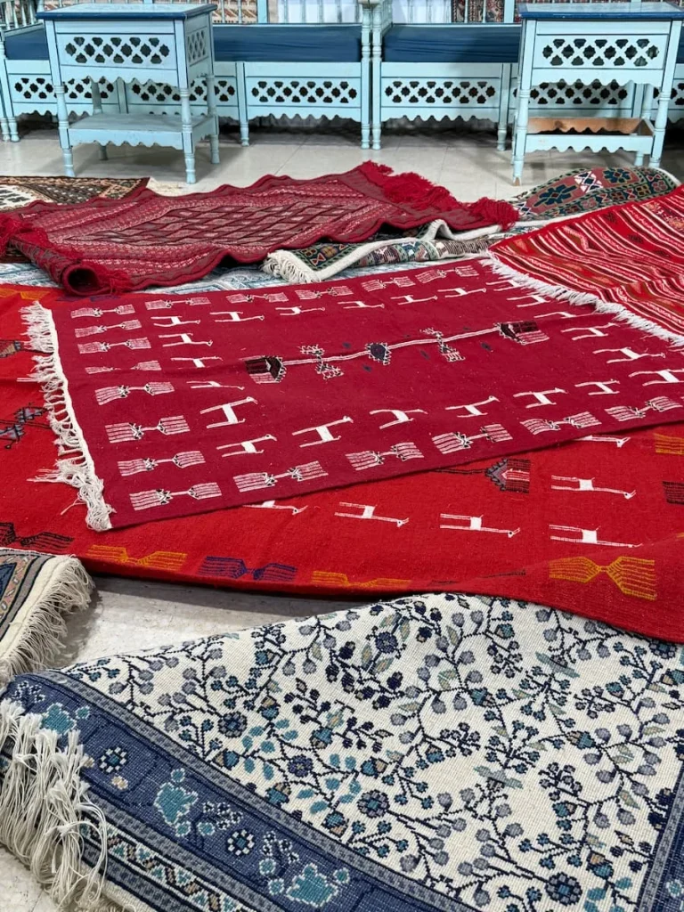Kairouan Government Carpet Shop with red, blue and brown carpets on the floor laid out
