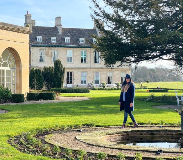 Stapleford Park Mansion side view with Bejal walking next to the pond